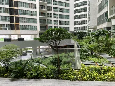a glass building with trees and plants in a city at Infinity Sky pool hostel best in Kuala Lumpur