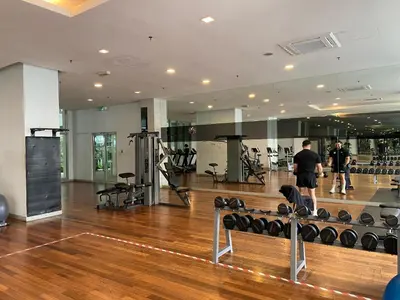 a man standing in a gym with weights at CloudNest Infinity Sky pool Hostel in Kuala Lumpur