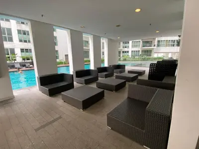 a lobby with chairs and a pool in a building at Skyfloat Infinity Hostel in Kuala Lumpur