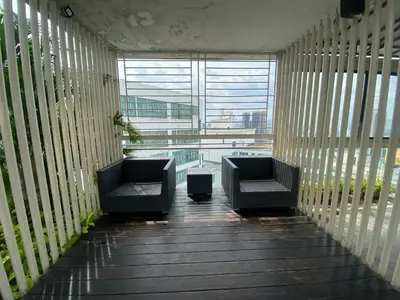 a balcony with two chairs and a large window at Skyfloat Infinity Hostel in Kuala Lumpur