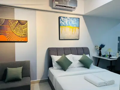 a bedroom with a bed and a chair and a table at The Luxe & Colony KLCC By Comfort Dwellings in Kuala Lumpur