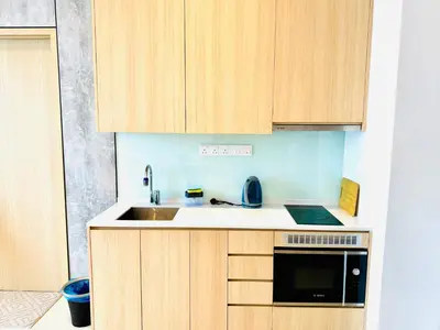 a kitchen with wooden cabinets and a sink at The Luxe & Colony KLCC By Comfort Dwellings in Kuala Lumpur