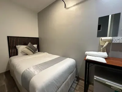 a small bedroom with a bed and a telephone at SS GREY HOUSE Jalan Alor in Kuala Lumpur