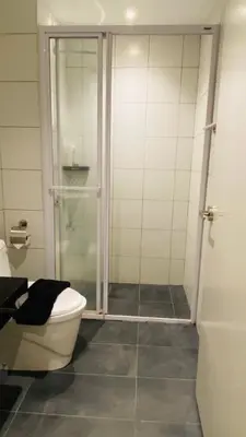 a bathroom with a toilet and a glass shower at chamber suites by bintang in Kuala Lumpur