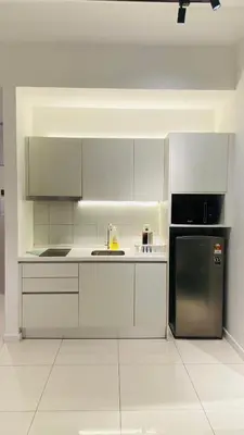 a white kitchen with a sink and a refrigerator at chamber suites by bintang in Kuala Lumpur