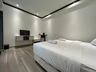 a white bedroom with a bed and a tv at Kingston Hotel by Minsu in Kuala Lumpur