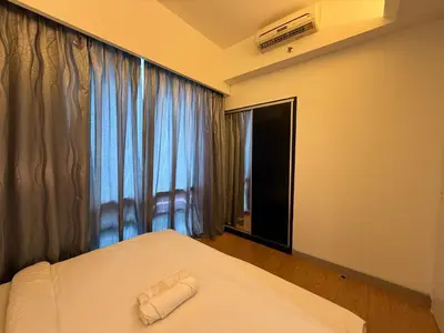 a bedroom with a bed and a window with a towel on it at Swiss Garden Residences by Roomy in Kuala Lumpur