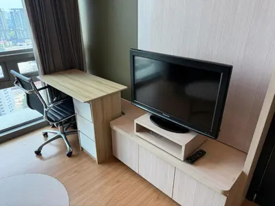 a room with a television and a desk and a chair at Swiss Garden Residences by Roomy in Kuala Lumpur