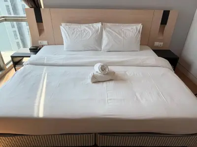a bed with a folded towel on top of it at Swiss Garden Residences by Roomy in Kuala Lumpur
