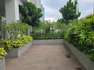 a walkway in a building with plants and trees at Quill Residence KL Suites in Kuala Lumpur