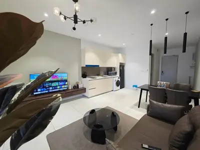 a living room with a couch and a dining room at Quill Residence KL Suites in Kuala Lumpur