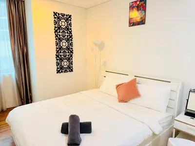 a bedroom with a bed with a stuffed animal on it at Mercu Summer Suites KLCC By Suite Apartment in Kuala Lumpur