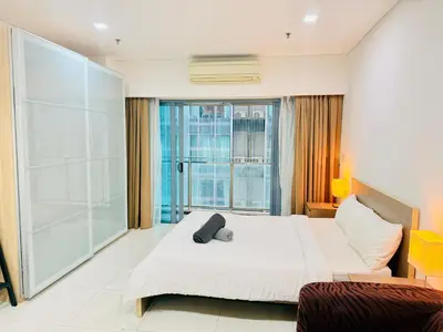 a hotel room with a bed and a large window at Mercu Summer Suites KLCC By Suite Apartment in Kuala Lumpur