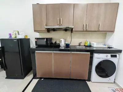 a kitchen with a black refrigerator and a dishwasher at Parkview Serviced Apartment Kuala Lumpur Twin Tower in Kuala Lumpur
