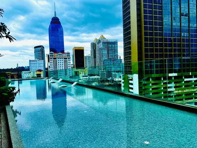 a large swimming pool with a city skyline in the background at Majestic Suites KLCC in Kuala Lumpur