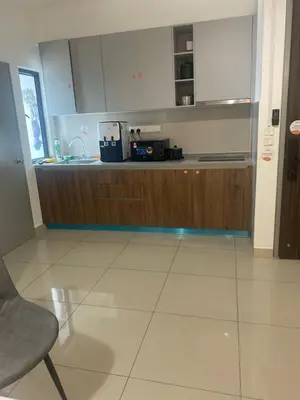 a kitchen with wooden cabinets and a counter top at Cozy Room in Kuala Lumpur