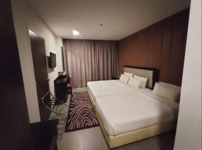 a hotel room with a large white bed in it at The Grand Campbell Hotel Kuala Lumpur in Kuala Lumpur