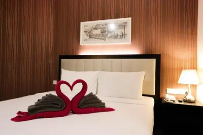 a bedroom with a bed with a heart pillow and mittens at The Grand Campbell Hotel Kuala Lumpur in Kuala Lumpur