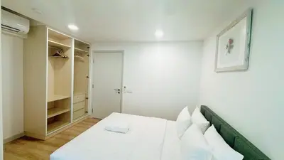 a white bedroom with a bed and a closet at The Atrium at Jalan Ampang by OKBnB - Classy Executive Family Suite 3Bedroom with Balcony , nearby KLCC in Kuala Lumpur