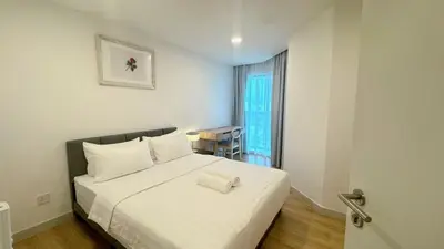 a bedroom with a large white bed with a window at The Atrium at Jalan Ampang by OKBnB - Classy Executive Family Suite 3Bedroom with Balcony , nearby KLCC in Kuala Lumpur
