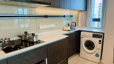 a kitchen with a stove and a washing machine at The Atrium at Jalan Ampang by OKBnB - Classy Executive Family Suite 3Bedroom with Balcony , nearby KLCC in Kuala Lumpur
