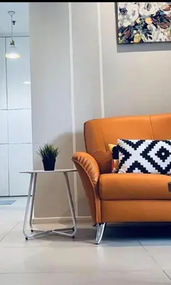 an orange couch and a table in a room at Arcoris SOHO by Cj in Kuala Lumpur