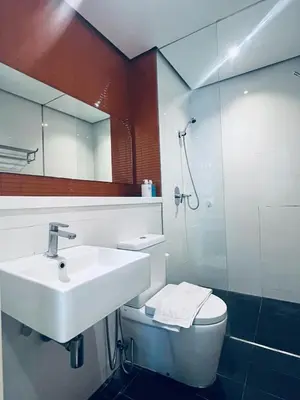 a bathroom with a sink and a toilet and a mirror at Arcoris SOHO by Cj in Kuala Lumpur