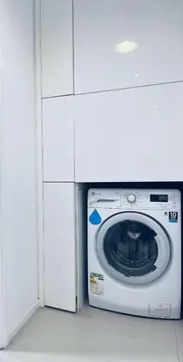 a white washing machine in a white cabinet at Arcoris SOHO by Cj in Kuala Lumpur