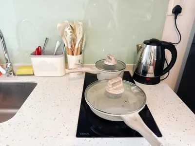 a kitchen counter with two pots and pans on a stove at Cozy Studio l Riveria City l 1km to KL Sentral in Kuala Lumpur
