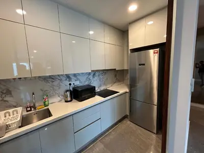 a kitchen with white cabinets and a sink and a refrigerator at PLATINUM SUITE by KUALALUMPUR MALAYSIA in Kuala Lumpur