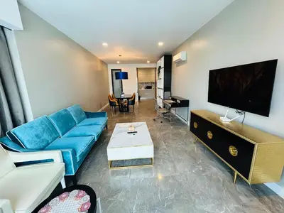a living room with a blue couch and a flat screen tv at PLATINUM SUITE by KUALALUMPUR MALAYSIA in Kuala Lumpur