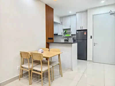 a kitchen with a table and chairs and a refrigerator at Aiman Damia Homestay in Kuala Lumpur