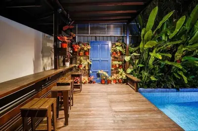 a restaurant with benches and a blue door and plants at 68 Palms 01 l Midvalley l KL Sentral l 5 Pax in Kuala Lumpur