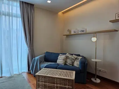 a living room with a blue couch and a table at Villa Homescape, Mont Kiara in Kuala Lumpur