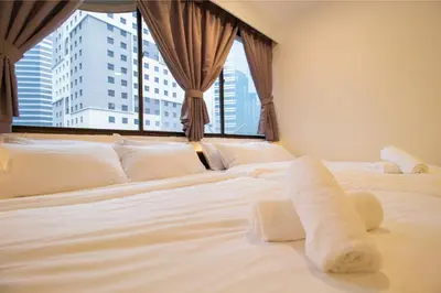 a large white bed in a room with a window at Downtown Condo KL City - 18 pax in Kuala Lumpur