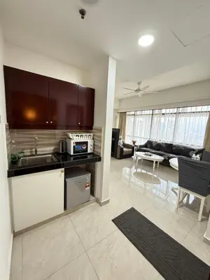 a kitchen and a living room with a couch at Times Residence At BTS Kuala Lumpur in Kuala Lumpur