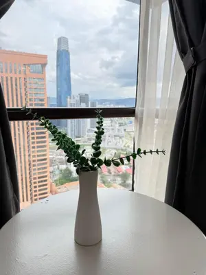 a white vase sitting on a table in front of a window at Times Residence At BTS Kuala Lumpur in Kuala Lumpur