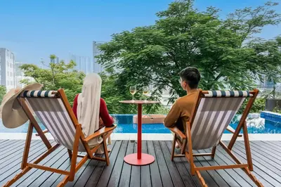a man and a woman sitting in chairs at a table at Flame of the Forest Retreat 38Pax 8R7B Pool Villa Kuala Lumpur in Kuala Lumpur
