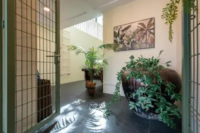 a hallway with plants and a large vase at Flame of the Forest Retreat 38Pax 8R7B Pool Villa Kuala Lumpur in Kuala Lumpur