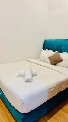 a large bed with towels on top of it at Chambers Serviced Suites Kuala Lumpur in Kuala Lumpur
