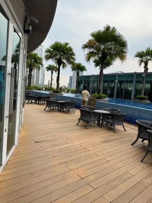 a person standing on a deck with tables and benches at Vortex Suites klcc City Malaysia in Kuala Lumpur