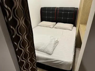 a small bed with a black headboard and white sheets at Vortex Suites klcc City Malaysia in Kuala Lumpur
