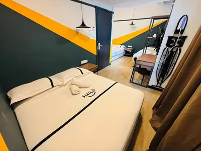 a bed in a room with a yellow and blue wall at Seeds Hotel Bukit Bintang in Kuala Lumpur