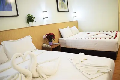 two swans are sitting on two beds in a hotel room at Xpeed Holiday Hotel in Kuala Lumpur
