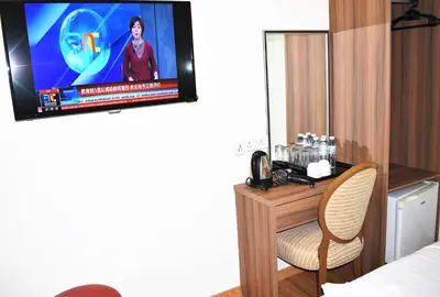 a hotel room with a tv and a chair in a room at Xpeed Holiday Hotel in Kuala Lumpur