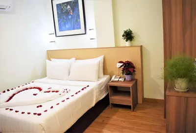 a hotel room with a bed and a table at Xpeed Holiday Hotel in Kuala Lumpur