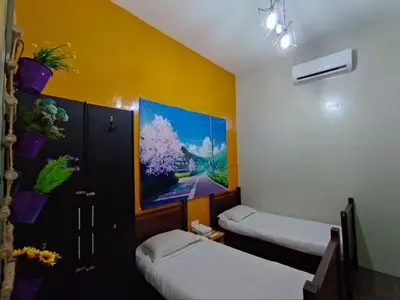 a room with two beds and a painting on the wall at The Ohana Suite in Kuala Lumpur