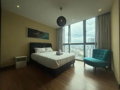 a bedroom with a bed and a blue chair at The Ohana Suite in Kuala Lumpur