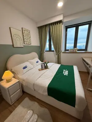 a bedroom with a large bed with a green blanket at Nest Heaven Host in Kuala Lumpur