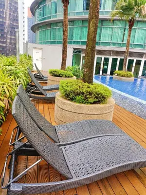 a couple of chairs sitting on a deck with trees at Vortex Premium Apartment klcc in Kuala Lumpur